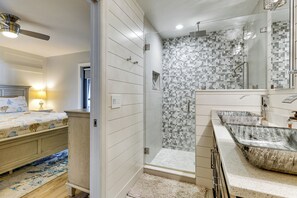 A modern bathroom with a shower, a large mirror, and a vanity with a sink. - Tropical Oasis in Lehigh Acres: Great for Groups! (Lehigh Acres)