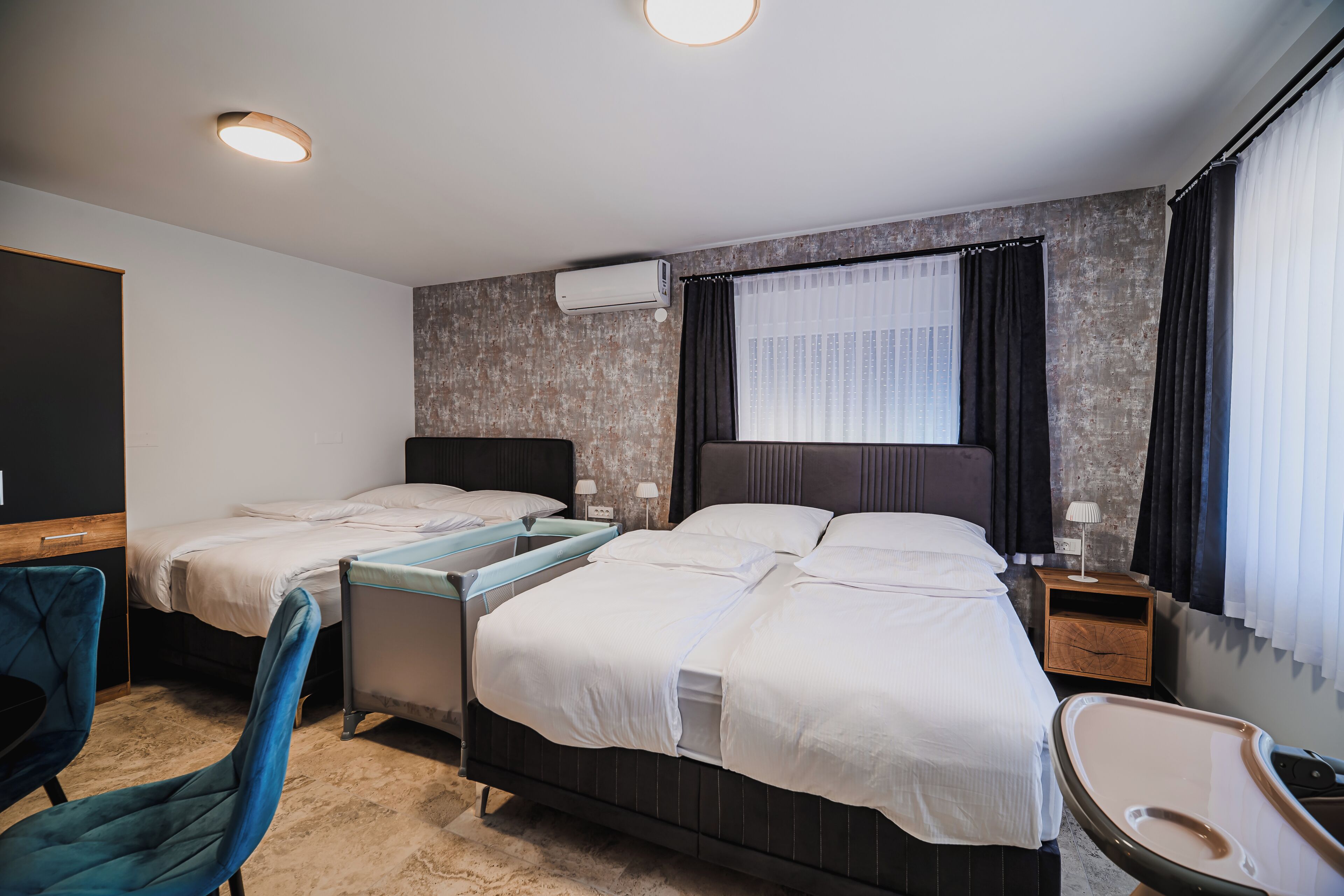 Una habitación de hotel con dos camas, un escritorio, una silla, una mesita y una bañera.