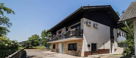A two-story building with a balcony, outdoor seating, and a clear sky.