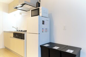 A kitchen with a microwave, refrigerator, dishwasher, and cabinets. - Mugenzaka by Tranova 2 (Shibuya)