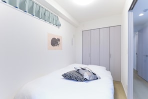 Quarto com cama, guarda-roupa, janela com cortinas e quadro na parede.