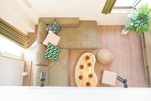 Una sala moderna con un sofá modular, una mesa de centro de madera y una planta colgante.