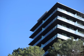 Un edificio moderno de varios pisos con balcones y ventanas amplias.