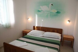 A bedroom with a bed, two bedside tables, a wall painting of a swan, and two wall-mounted lights. - Srima Villa Steps from Sandy Beach (Srima)