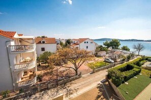 Un quartier résidentiel situé sur la côte, avec des bâtiments blancs, des balcons et une vue sur la mer.