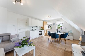 Um apartamento moderno com área de refeições, cozinha e sala de estar.