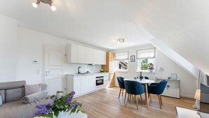 A modern apartment with a dining area, kitchen, and living space. - Conwind 2 - House Conwind. - Apartment 2 (78 m²). In Keitum for up to 4 people (Sylt)
