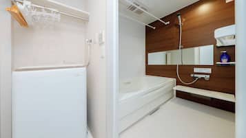 A modern bathroom with a white bathtub, a shower, a towel rack, and a mirror.