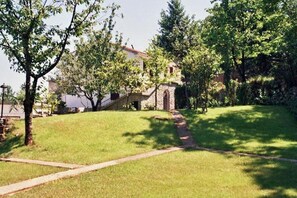 A grassy area with a stone staircase leading to a building with a red roof. - Sea View Apt with Terrace Kitchen (Opatija)