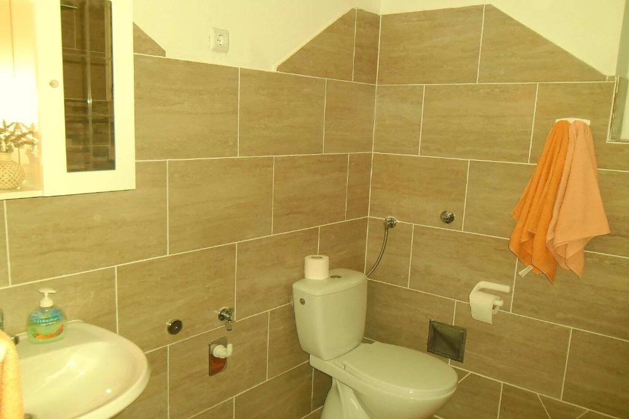 A bathroom with a toilet, sink, and towel rack.