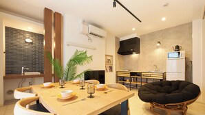 Cocina moderna con comedor, que incluye una mesa de madera, sillas y una silla negra original.