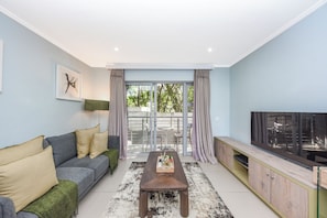 Ein Wohnzimmer mit Sofa, Couchtisch und TV-Schrank.
