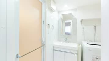 Combined shower/bathtub, hair dryer, slippers, towels