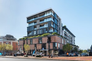 A multi-story building with a modern design, featuring a prominent 'GEAR CHANGE' sign, large windows, and a brick facade. - The Signature | Designer De Waterkant Retreat (Cape Town)