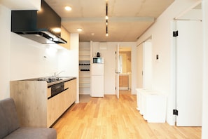 Una cucina moderna con piano cottura integrato, forno a microonde e mobili bianchi.