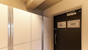 A hotel room with a check-out time sign, a door with a handle, and a wall-mounted sign. - FrontierComfortKitaIkebukurobyTranova 2 (Toshima City)