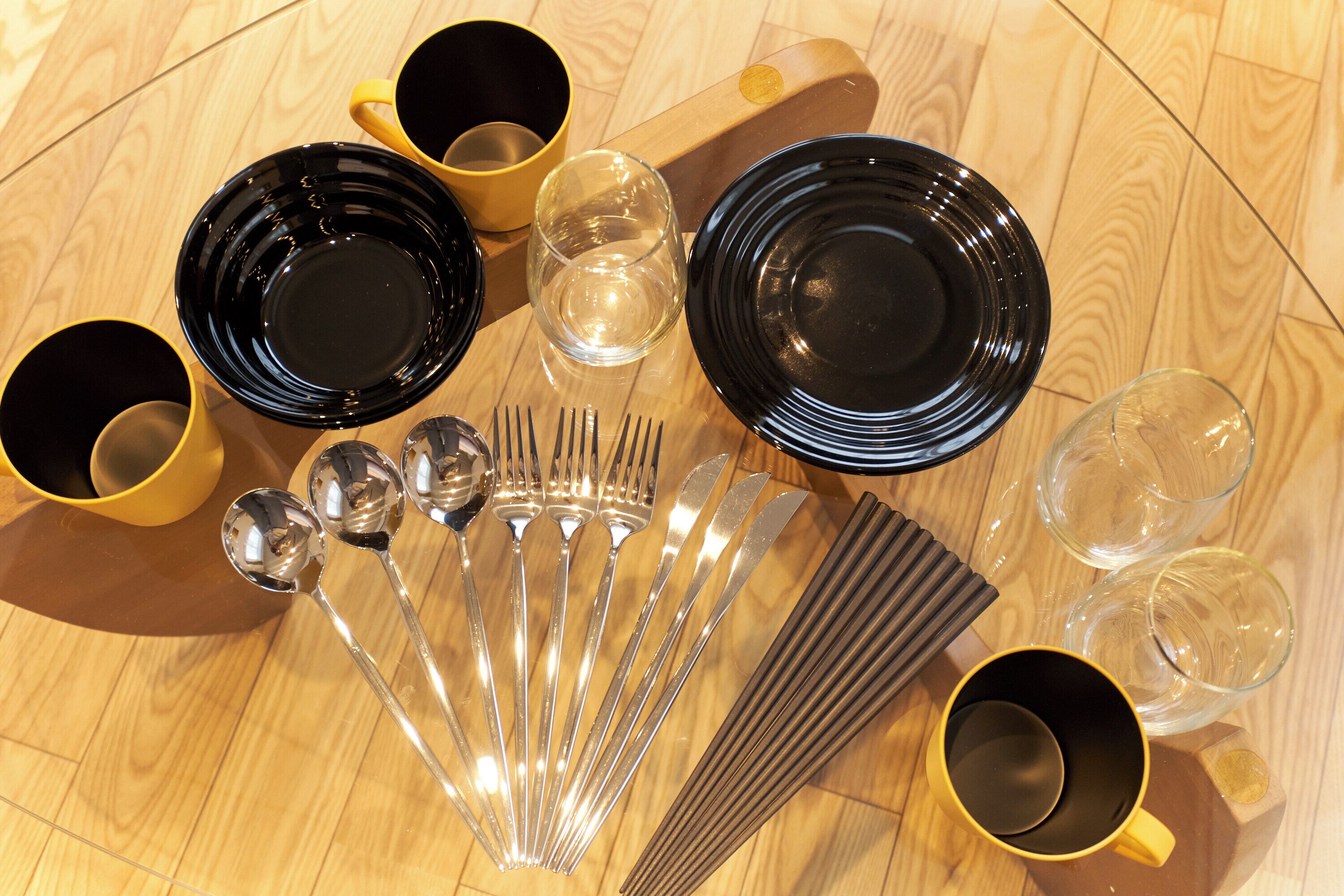 A table with various dining utensils and dishes.