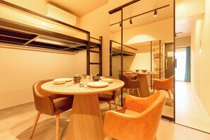 A modern dining area with a round table, chairs, and a glass partition. - DeLCCS Ryogoku 2 (Sumida City)