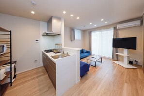 Ein modernes Apartment mit Küche, Wohnbereich und Fernseher.