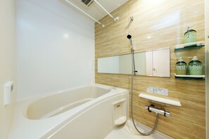 Un baño moderno con bañera, ducha y espejo.