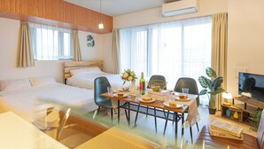 A hotel room with a bed, a dining table with chairs, a television, and a potted plant. - MODELLO Sangenjaya by Tranova 2 (Setagaya City)