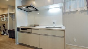 A modern kitchen with a stainless steel range hood, a sink, and a dishwasher. - AI Grandir Azumabashi 2 (Sumida City)