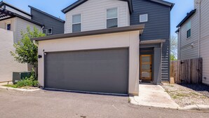 Ein Wohngebäude mit Garage, Hauseingang und kleiner Veranda.