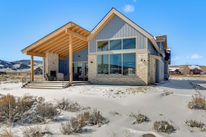 A modern two-story house with a stone facade, large windows, and a wooden porch. - 4 Mi to Granby Ranch: Luxe Group Getaway! (Granby)