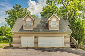 Ein zweistöckiges Haus mit Garage, Treppe und Holzzaun.