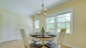 A dining room with a round table, white chairs, and a chandelier. - Dublin Retreat Near Golf, Weddings & Tournaments (Dublin)