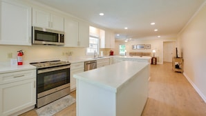 A modern kitchen with white cabinetry, stainless steel appliances, and a large island. - Dublin Retreat Near Golf, Weddings & Tournaments (Dublin)