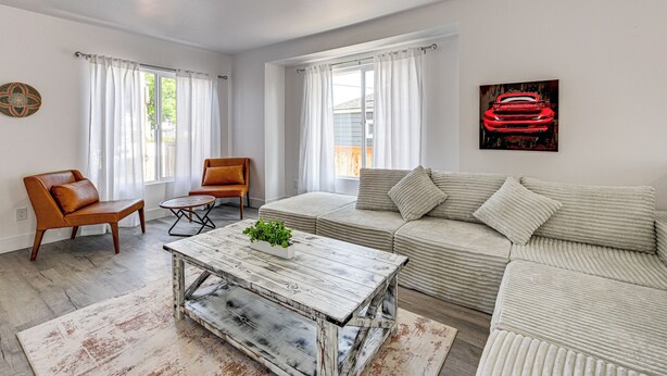 A living room with a sofa, two armchairs, a coffee table, and a painting on the wall. - Updated + Modern Craftsman Bungalow in Renton! (Renton)