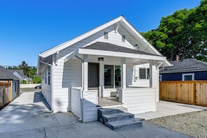 A single-story house with a front porch, a garage, and a fenced backyard. - Updated + Modern Craftsman Bungalow in Renton! (Renton)