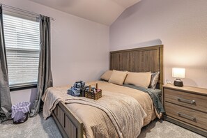 Un dormitorio con cama, mesita de noche y lámpara.