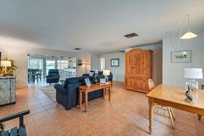 A spacious living area with a sofa, wooden table, and a dining table. - Johnson Bay Hideaway: Bayfront Naples Home w/ View (Naples)