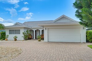 A single-story house with a garage, a driveway, and a well-maintained garden. - Johnson Bay Hideaway: Bayfront Naples Home w/ View (Naples)