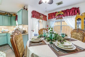 A dining area with a table set for four, chairs, and a window with curtains. - 4 Mi to Lake Houston! Single-Level Home w/ Yard (Humble)