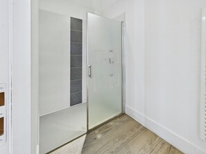 A modern bathroom with a glass shower enclosure, a white tiled wall, and a wooden floor. - Large house located in the Parc de Pierre Brune-Fôret de Mervent-all comforts (Mervent)