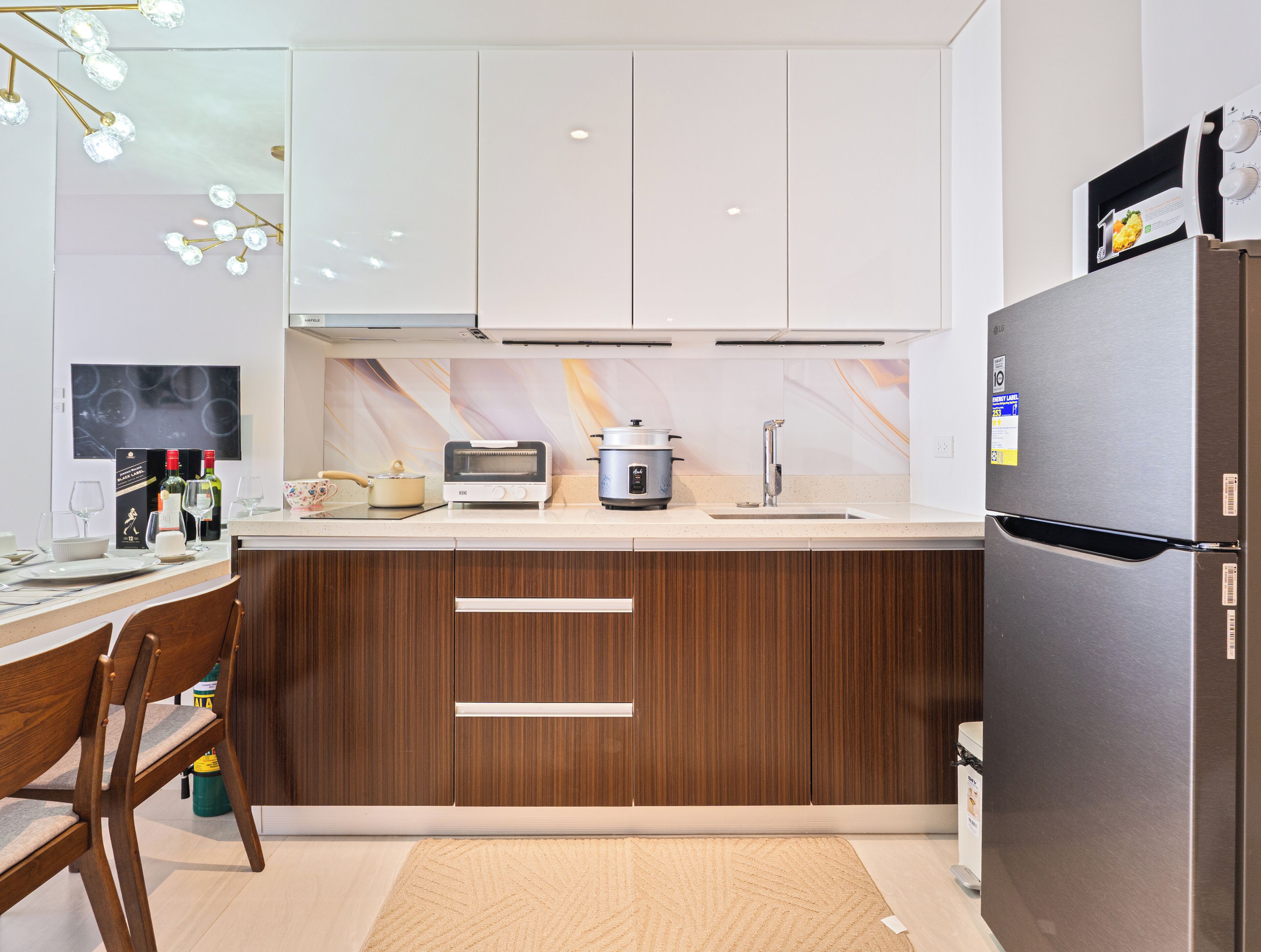 A modern kitchen with a built-in oven, a refrigerator, and a microwave.