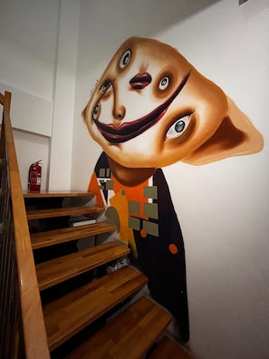 Una escalera con escalones de madera y una obra de arte en la pared.