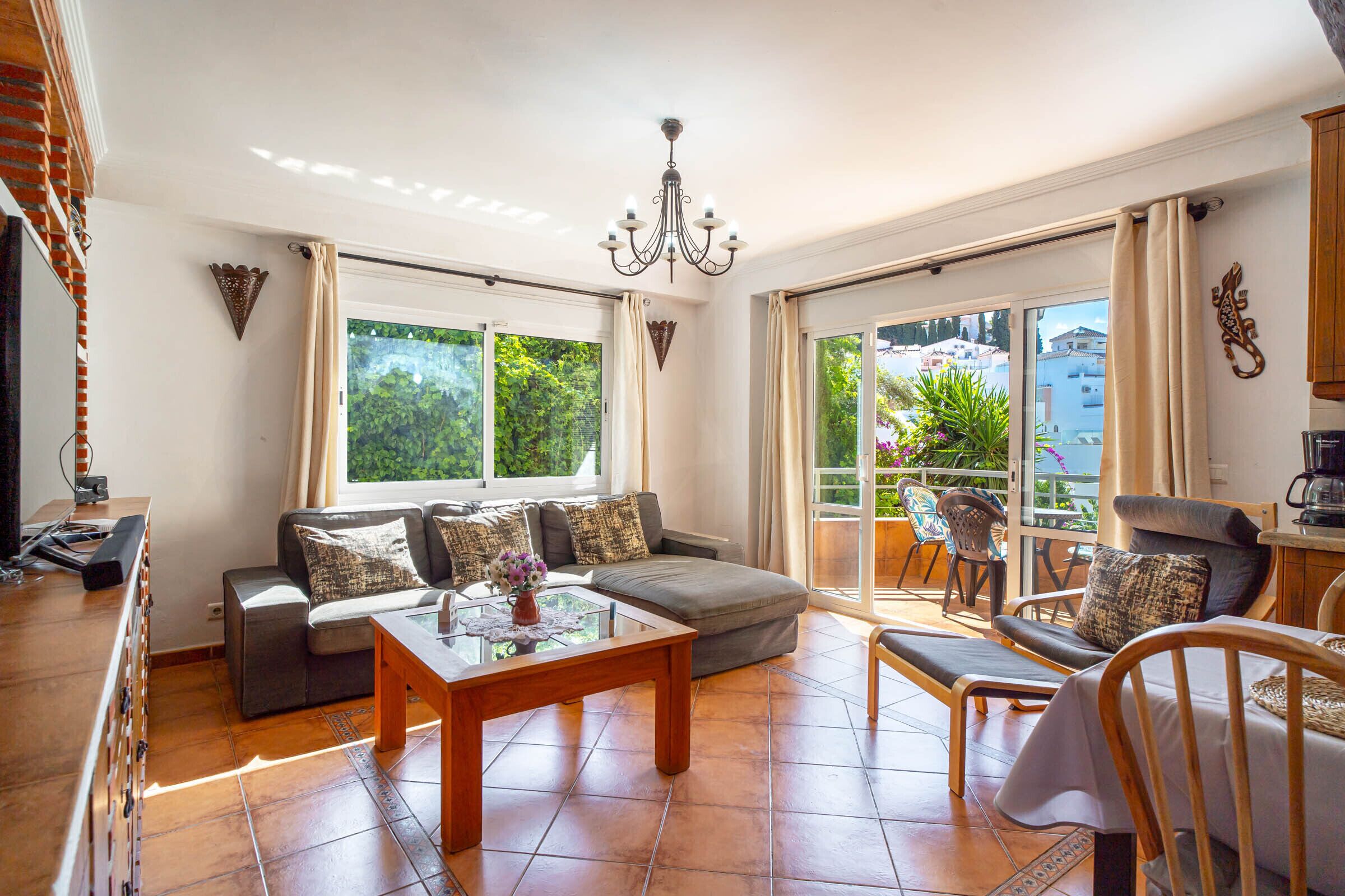A living room with a sofa, a coffee table, and a dining area with chairs.