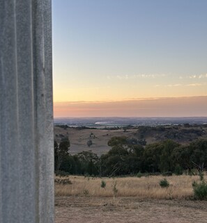 A landscape view with a distant horizon, trees, and a field.