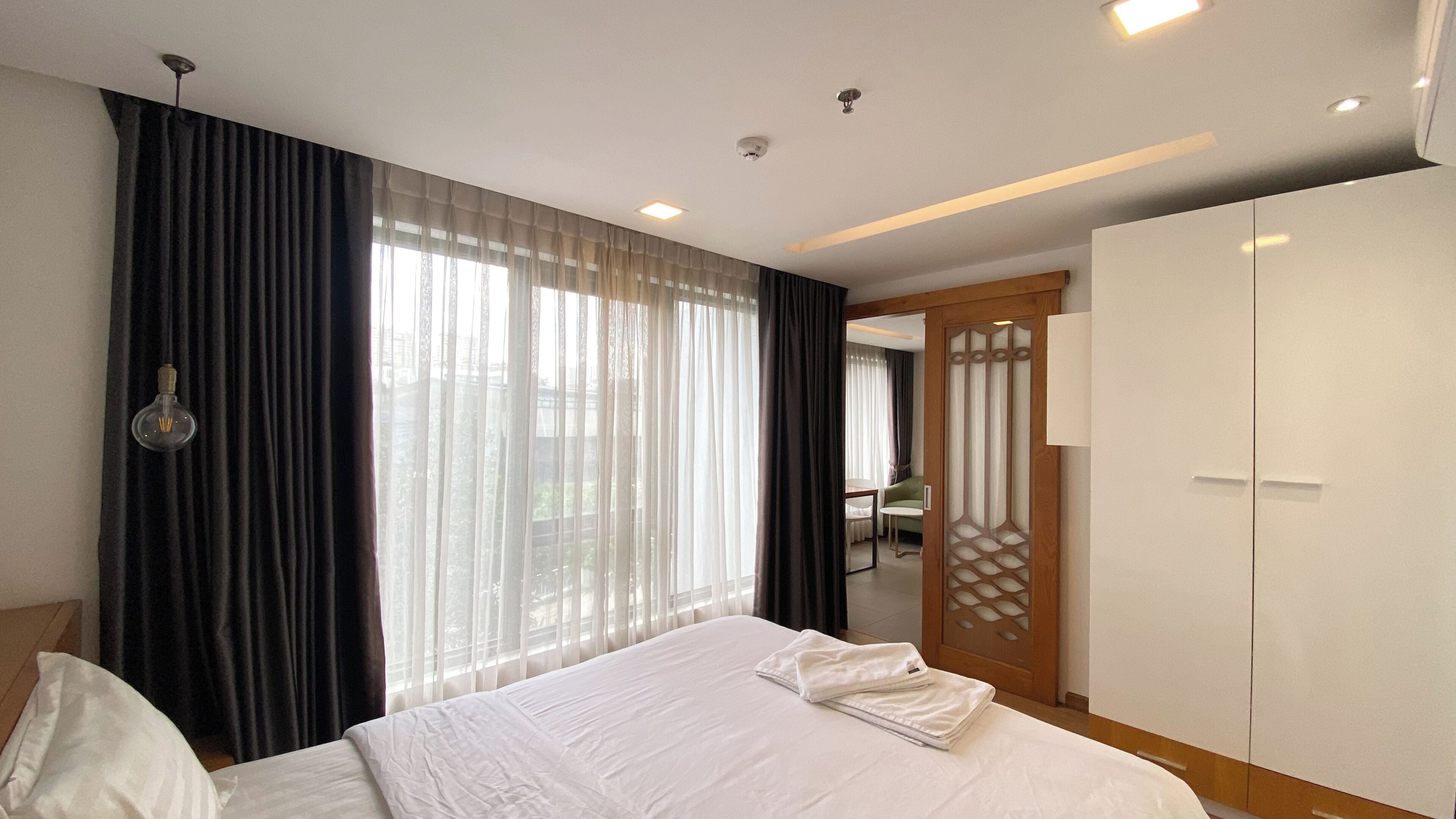 Una camera d'albergo con un letto grande, un armadio e vista dalla finestra.