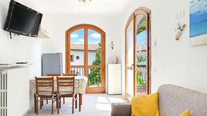 A living room with a sofa and a television mounted on the wall. - Casa Del Paperotto (Peschiera del Garda)