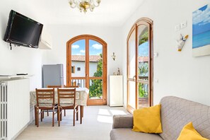 Ein Wohnzimmer mit einer Couch und einem an der Wand befestigten Fernseher.