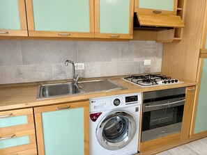 A kitchen with a stainless steel sink, a gas stove, an oven, and a built-in washing machine. - Casa Nina - In downtown Pontedassio, 5 minutes from Imperia, by HOST4U (Pontedassio)