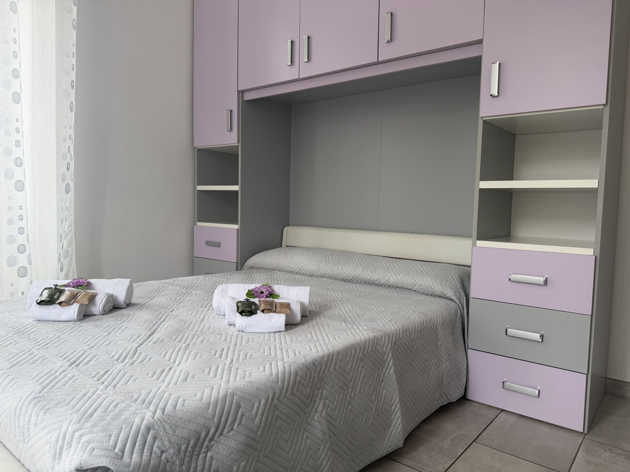 A bedroom with a bed, a wardrobe, and a nightstand.
