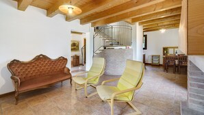 A room with a wooden ceiling, a sofa, two armchairs, a staircase, and a dining area. - Apartment 'Iris' with Private Terrace, Wi-Fi and Air Conditioning (Mirano)