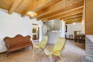 A room with a wooden ceiling, a sofa, two armchairs, a staircase, and a dining area. - Apartment 'Iris' with Private Terrace, Wi-Fi and Air Conditioning (Mirano)