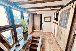 A narrow corridor with wooden flooring, a staircase, and large windows. - Holiday home with 2 bedrooms (Kottenheim)